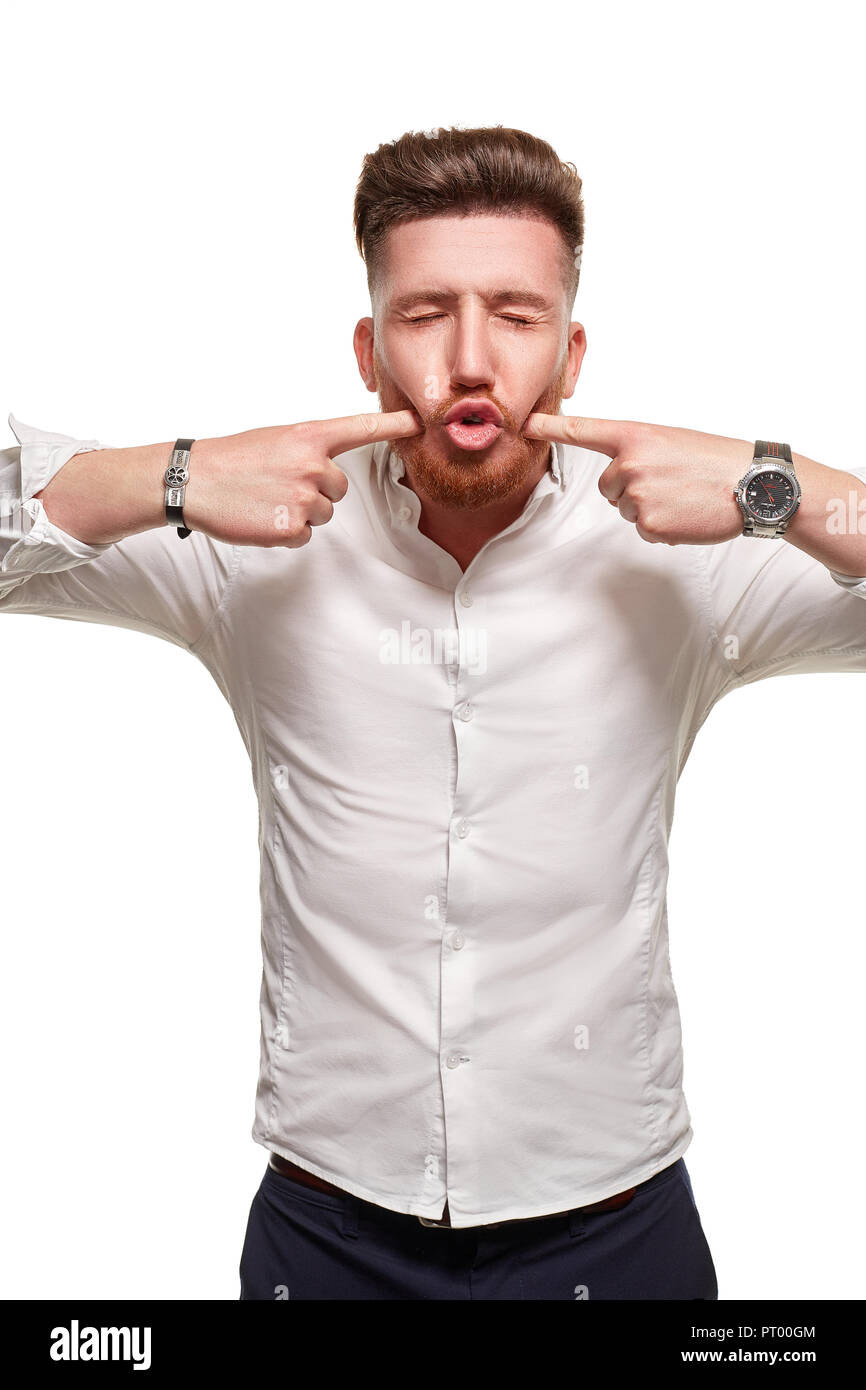 Handsome man wearing a white shirt, pressing on cheeks by his fingers ...