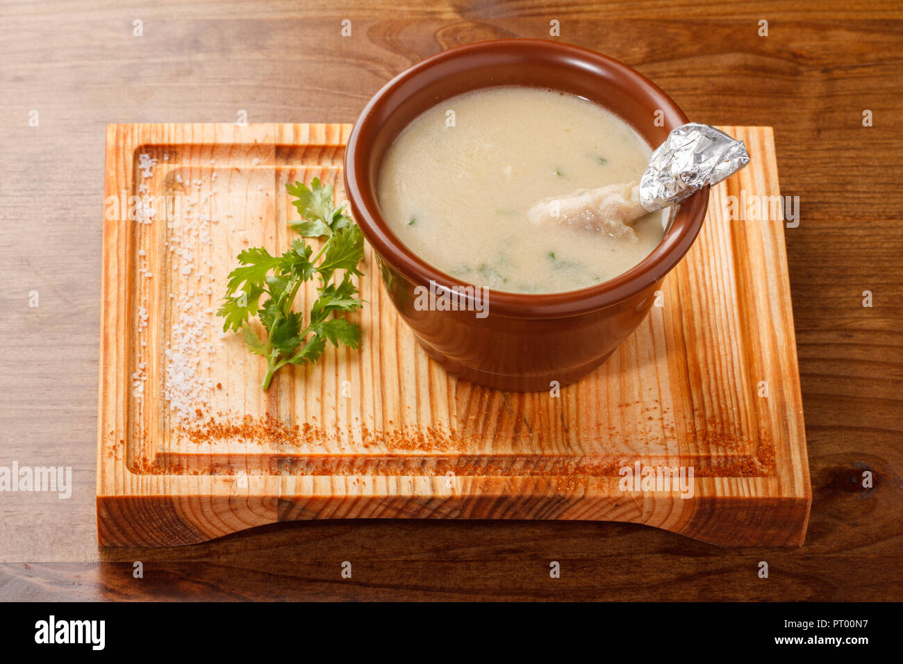 Creamy Chicken Drumsticks Soup served in a clay pot on top of a wooden board Stock Photo Alamy