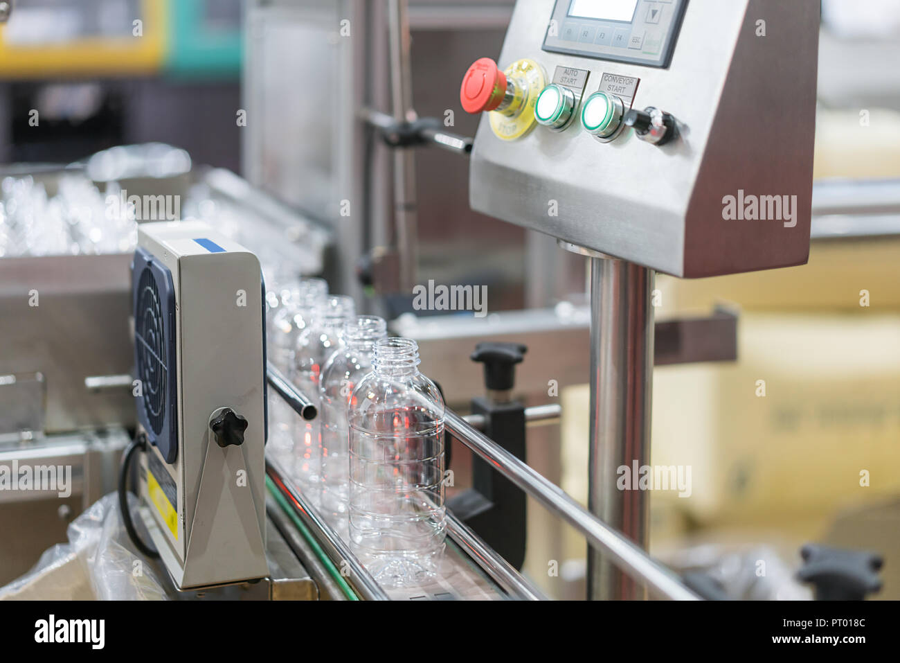 Clear water Bottles transfer on Conveyor Belt System. Industrial and factory with machine technology concept. Stock Photo