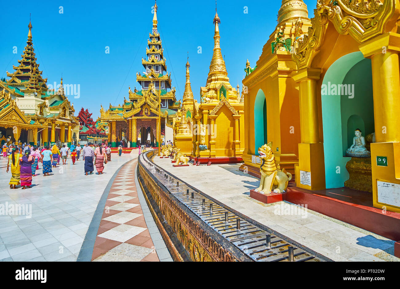 YANGON, MYANMAR - FEBRUARY 27, 2018: The outer stupas of Shwedagon Pagoda with altar for candles and incense sticks, stretching to Kassapa Buddha Imag Stock Photo