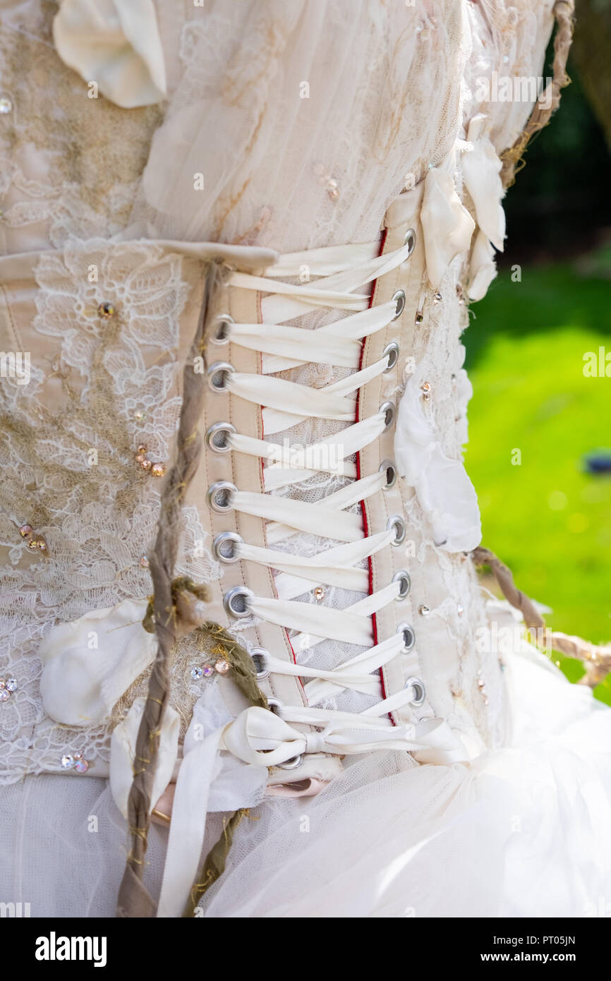 Back of cream and lace wedding dress showing the corset back and the lacing  done up firmly for slimming effect and in support Stock Photo - Alamy