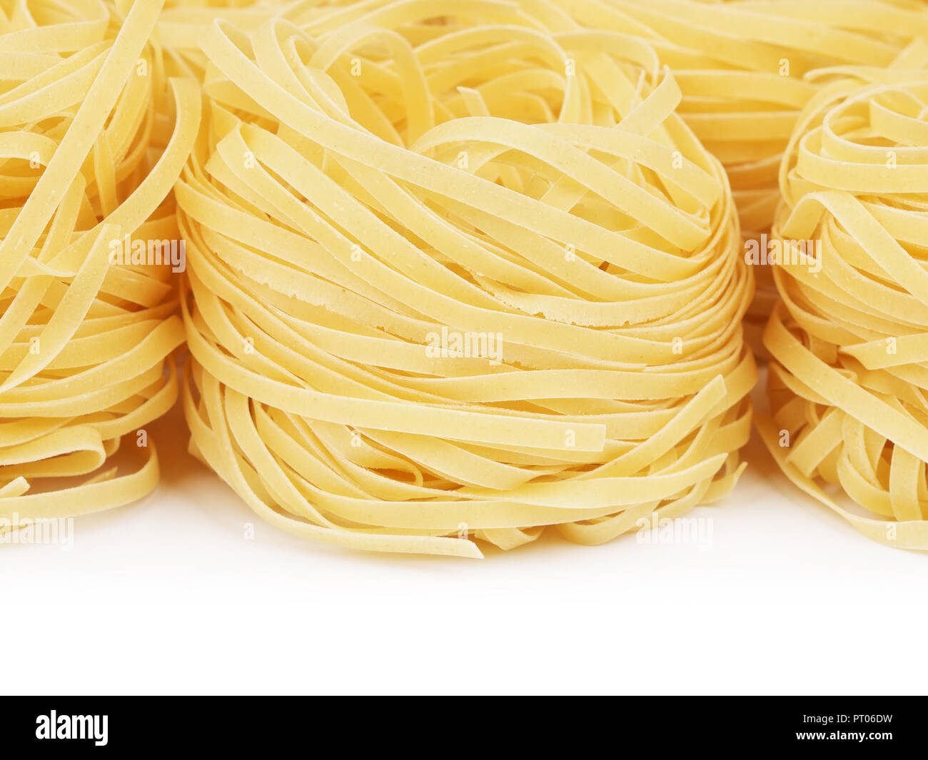 raw pasta tagliatelle nest lying on table Stock Photo