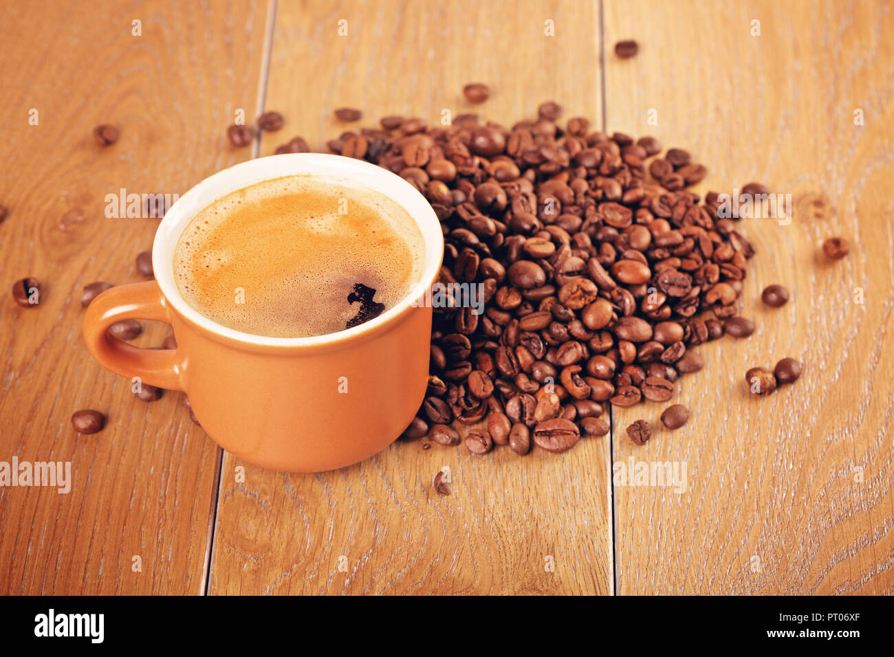 cup of espresso and coffee beans on wooden table Stock Photo
