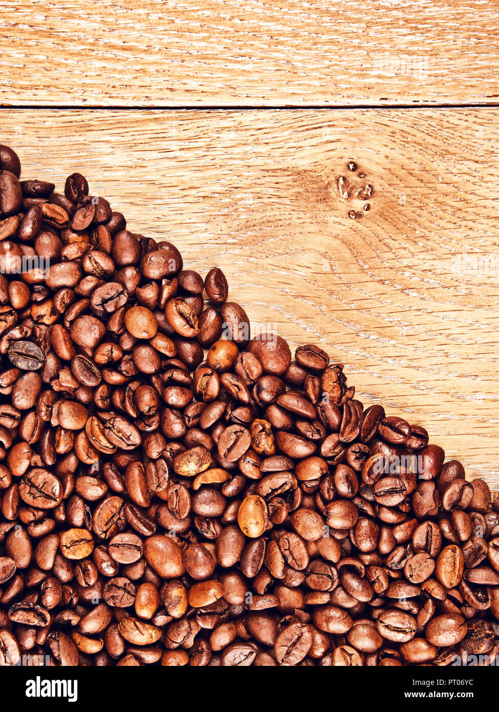 roasted coffee beans on wooden table, background Stock Photo