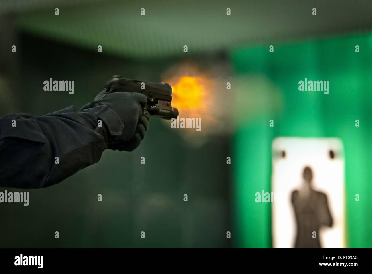A man practices a polygon shooting at the silhouette, takes aim and shoots. Stock Photo