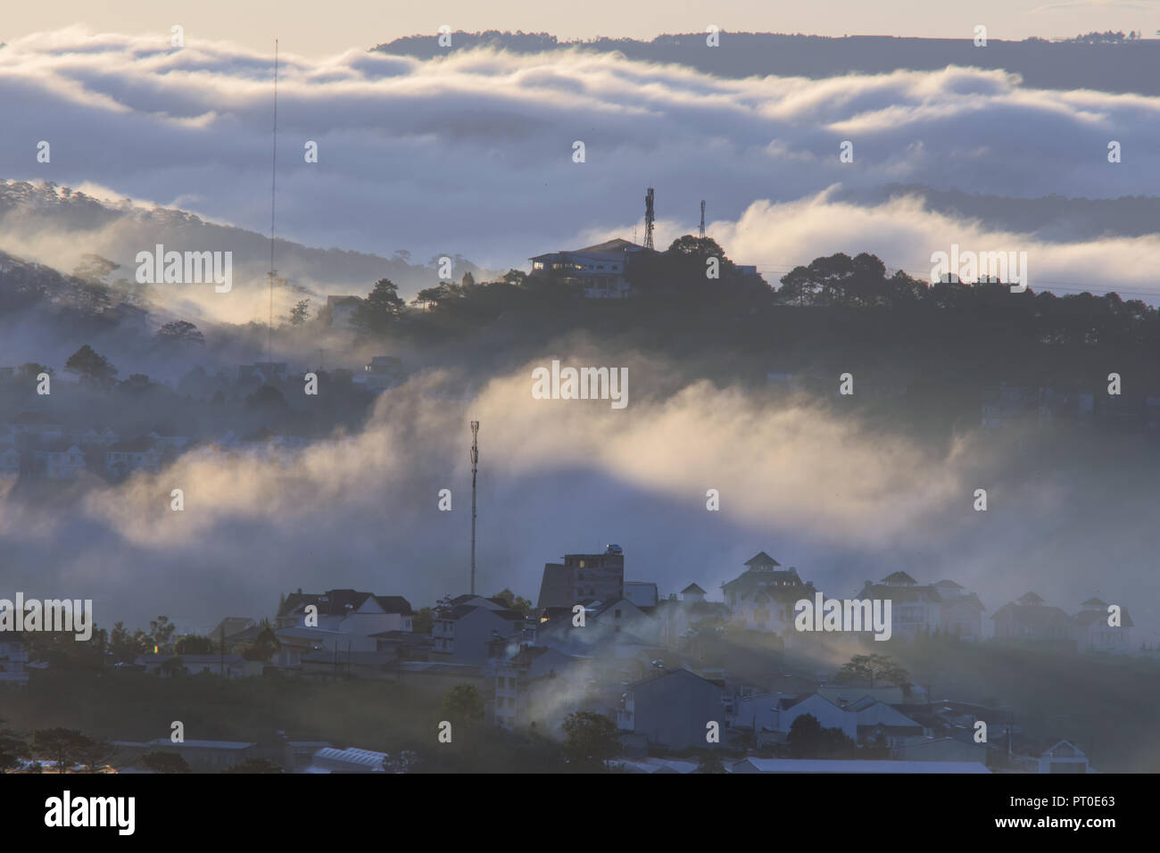 The fog cover Dalat plateau lands, Vietnam, background  with magic of the dense fog and sun rays, sunshine at dawn Stock Photo