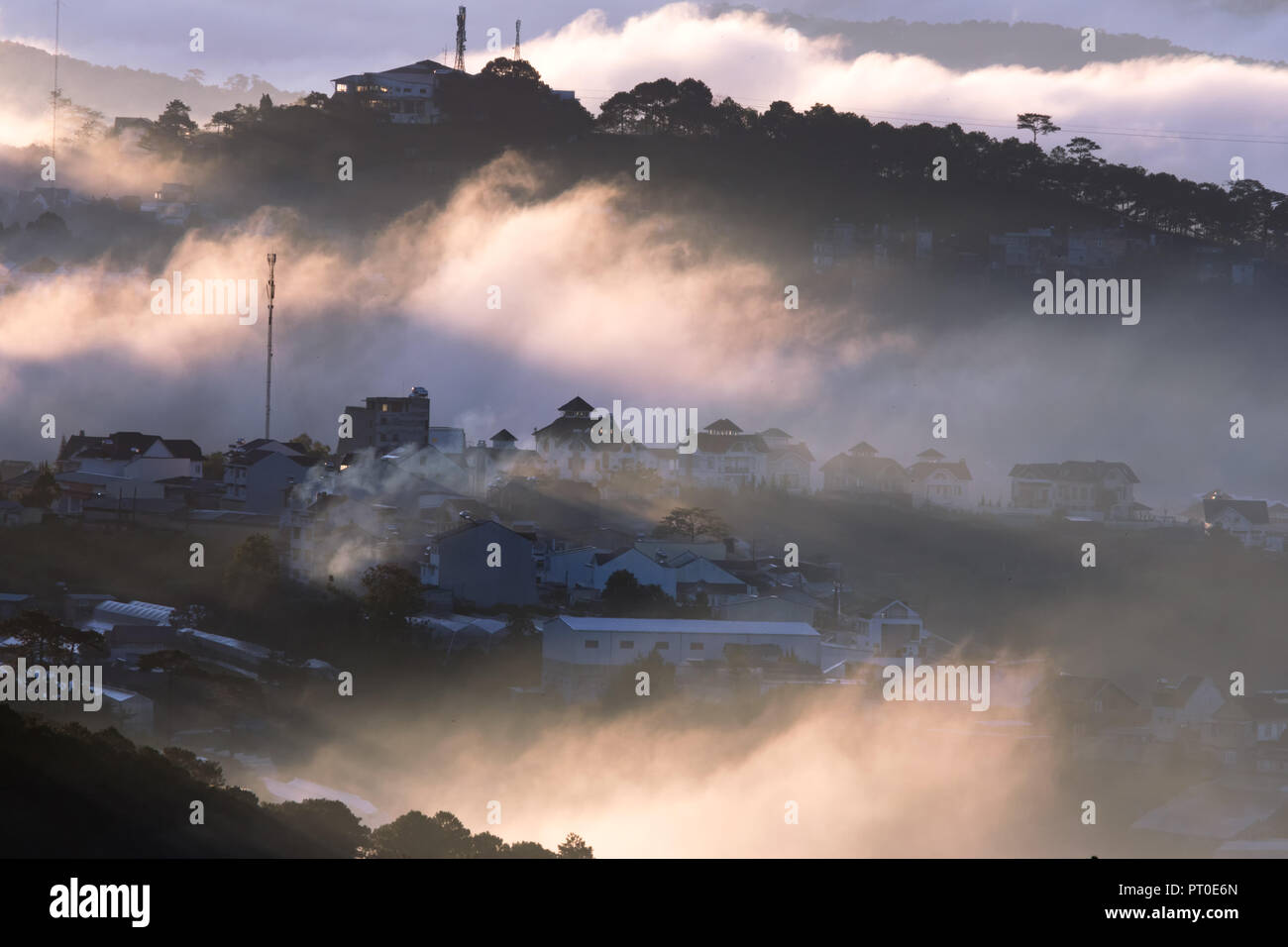 The fog cover Dalat plateau lands, Vietnam, background  with magic of the dense fog and sun rays, sunshine at dawn Stock Photo