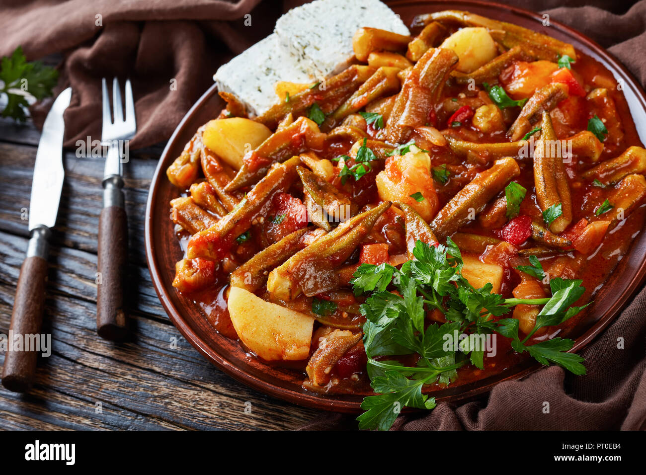 Greek okra stew with potato served with feta cheese slices on a ...