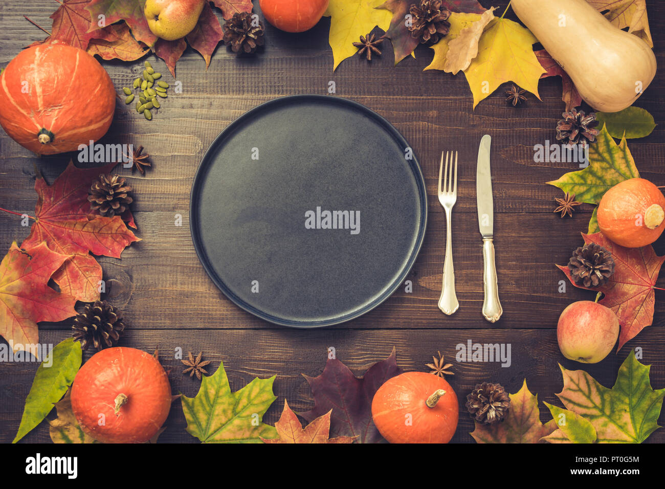 Autumn and Thanksgiving day table setting with fallen leaves, pumpkins ...