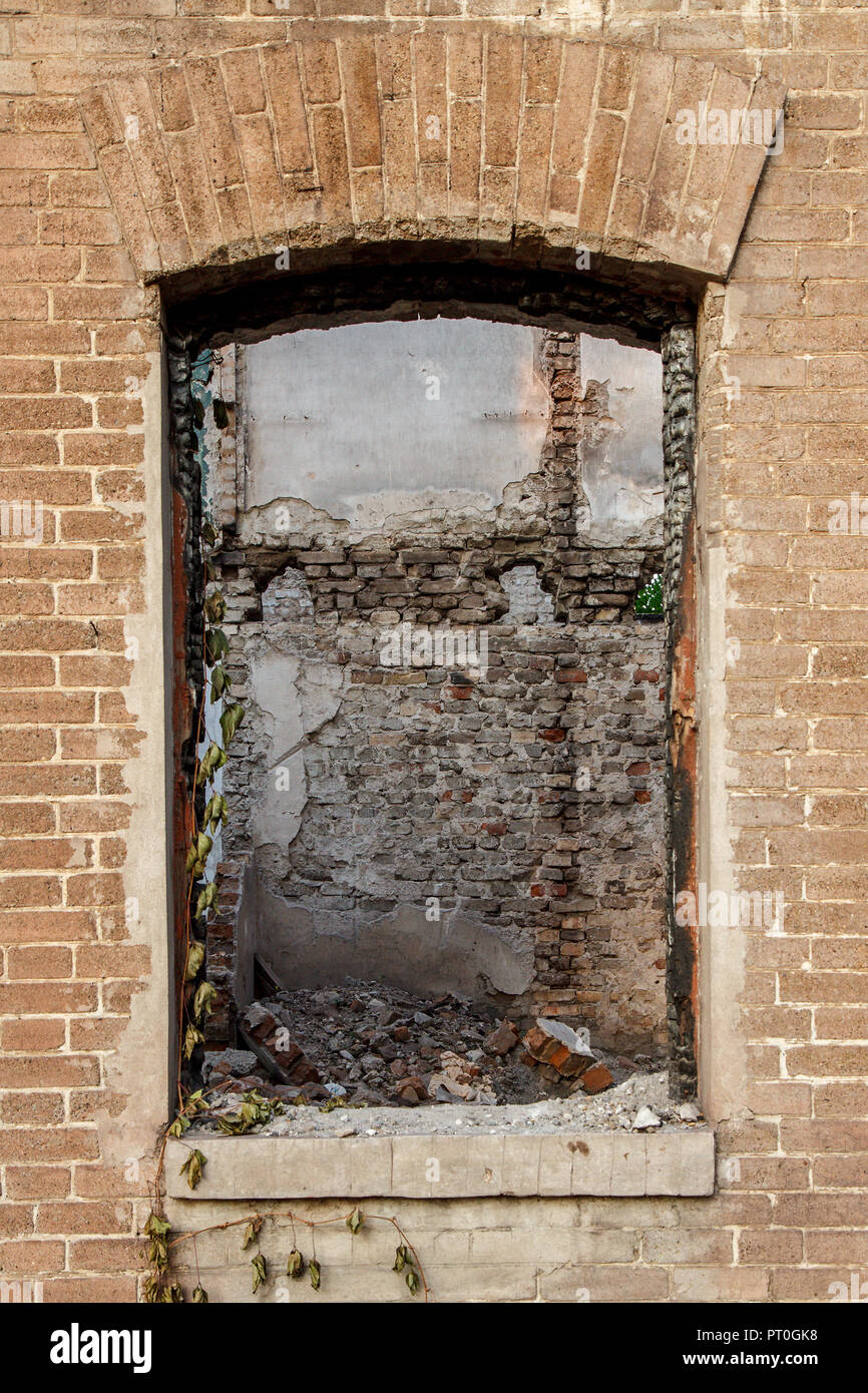 Window with fragment of ruined back wall in old abandoned brick ...