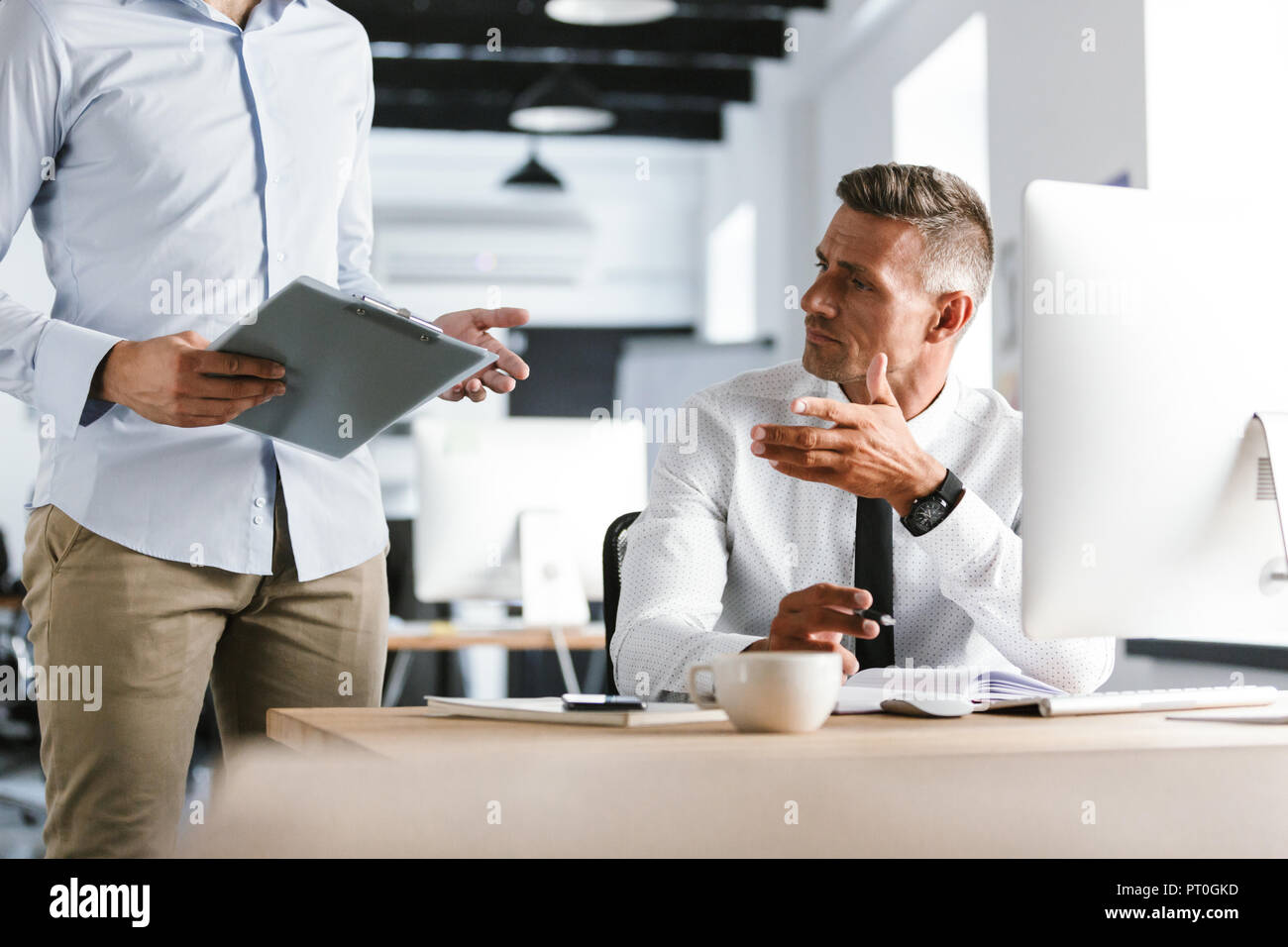 Cropped image of Two colleagues working together with documents while being in office Stock Photo