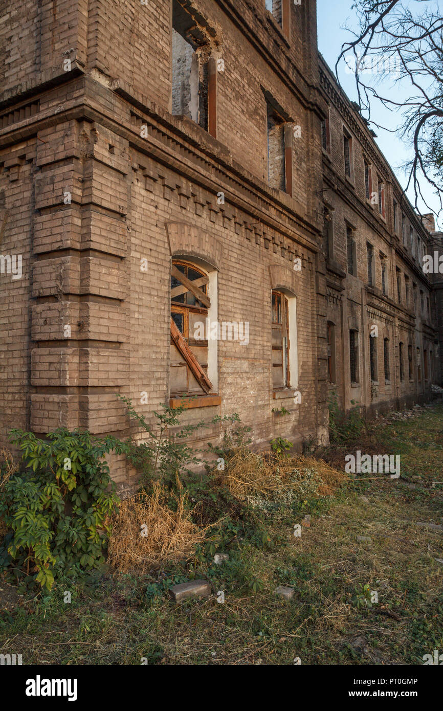 Facade of old abandoned brick building with window lined with wooden ...