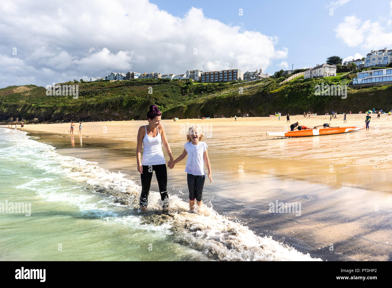 Mother and Daughter happy, smiling, paddling, walking in the sea at the gorgeous St Ives in Cornwall, UK, the stunning Carbis Bay Stock Photo