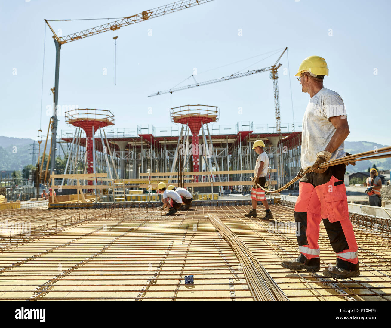 Workers on construction site preparing iron rods Stock Photo