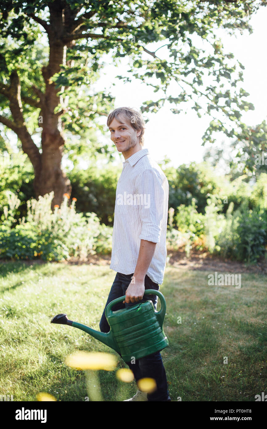 Man with watering can in garden Stock Photo