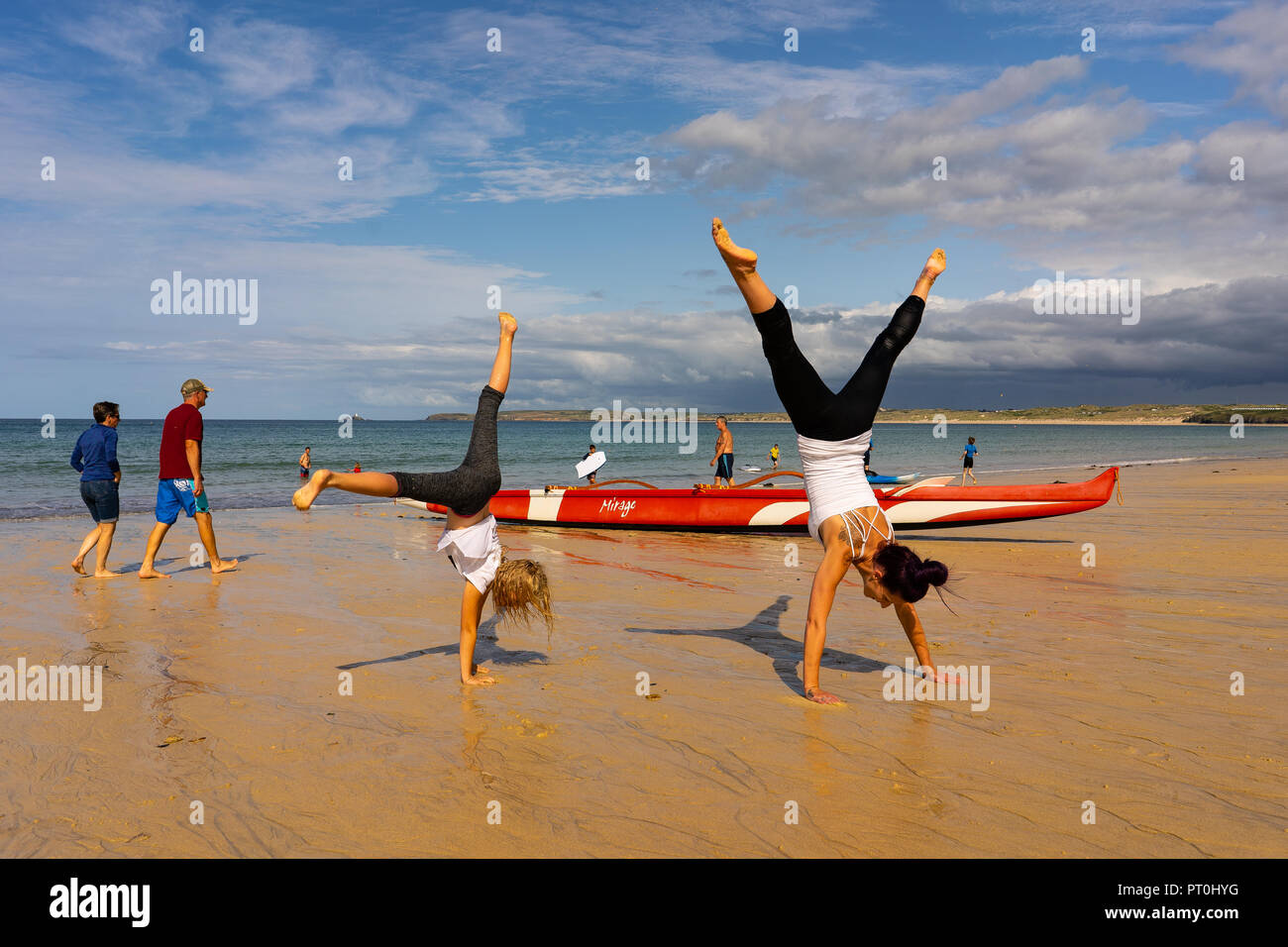 Mother and daughter having fun at the beautiful Carbis Bay in St Ives, Cornwall, Cartwheeling on the beach together Stock Photo