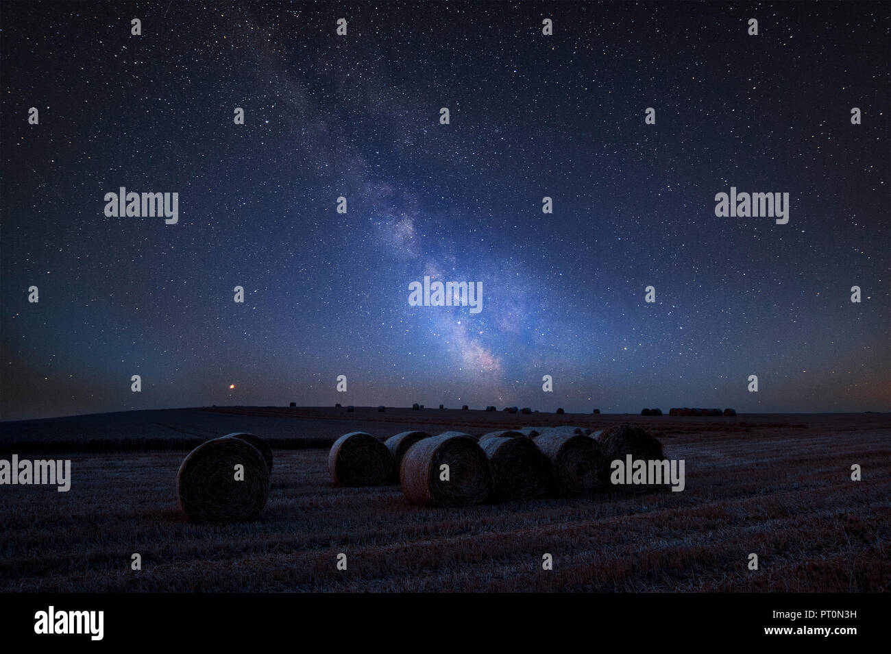 Stunning vibrant Milky Way composite image over landscape of Lovely hay ...