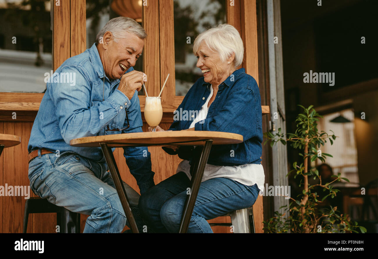 Cheerful old couple sitting at cafe having a coffee. Senior man and ...