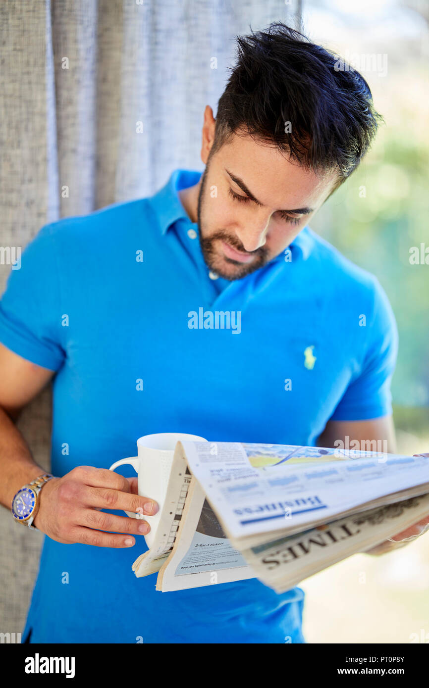 Man contemplating reading a paper Stock Photo