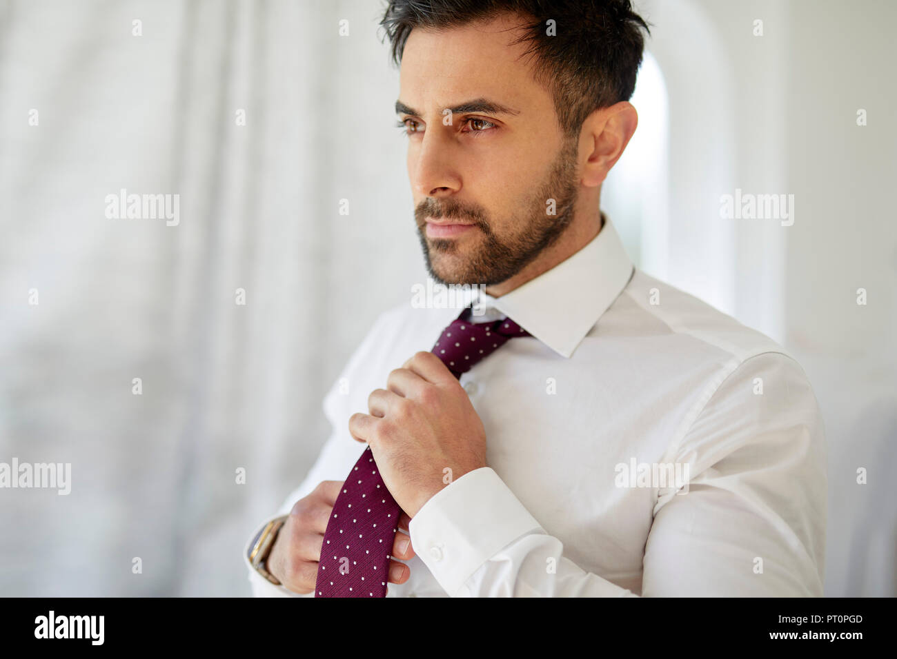 Man adjusting his tie Stock Photo