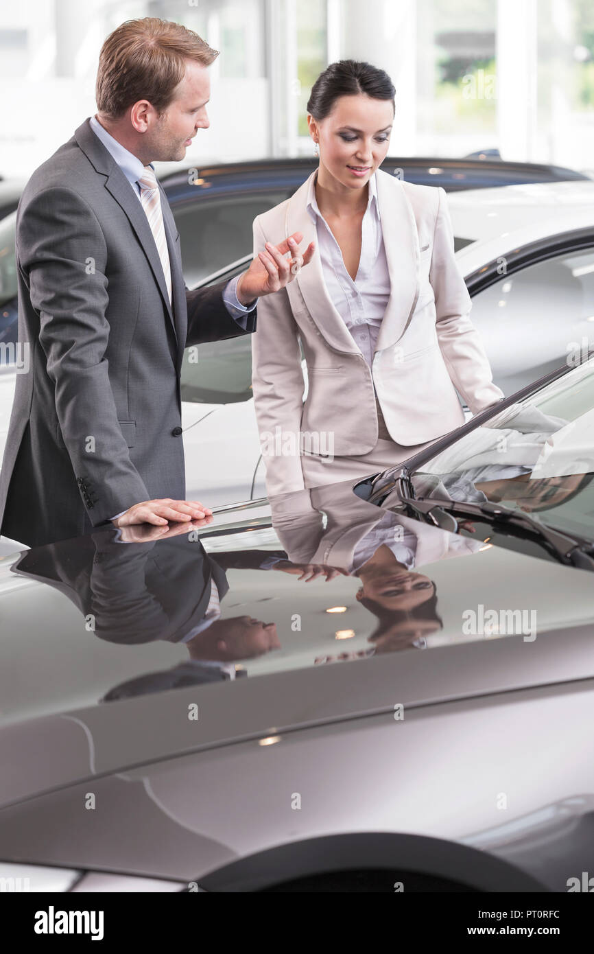 At the car dealer, Salesman showing new car to client Stock Photo