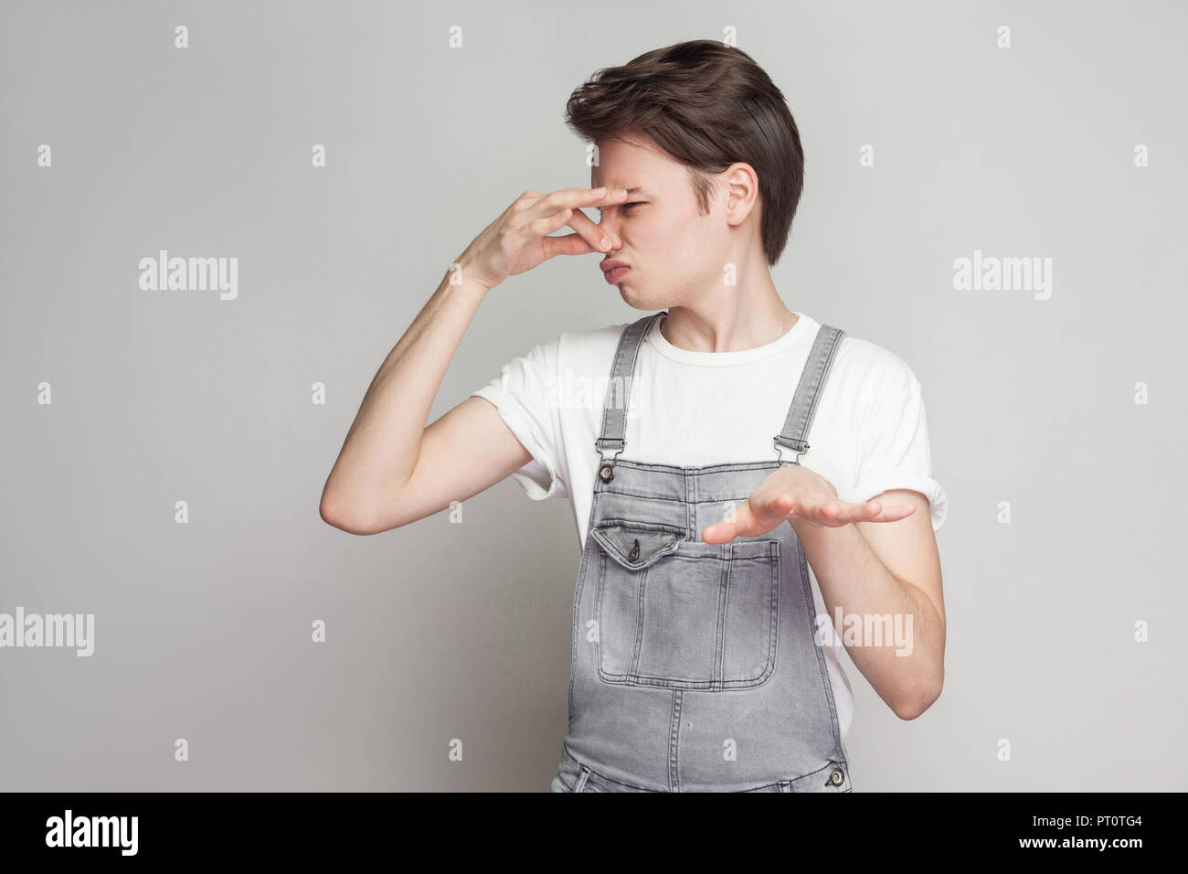 bad smell, go away from here. Young man in casual style with white tshirt and denim