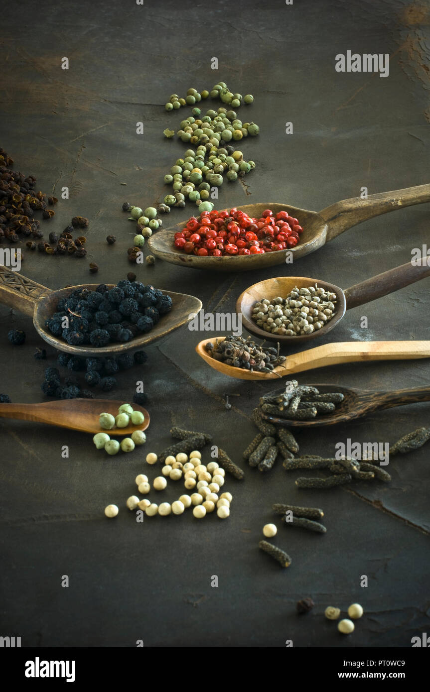 Various sorts of pepper on spoons Stock Photo