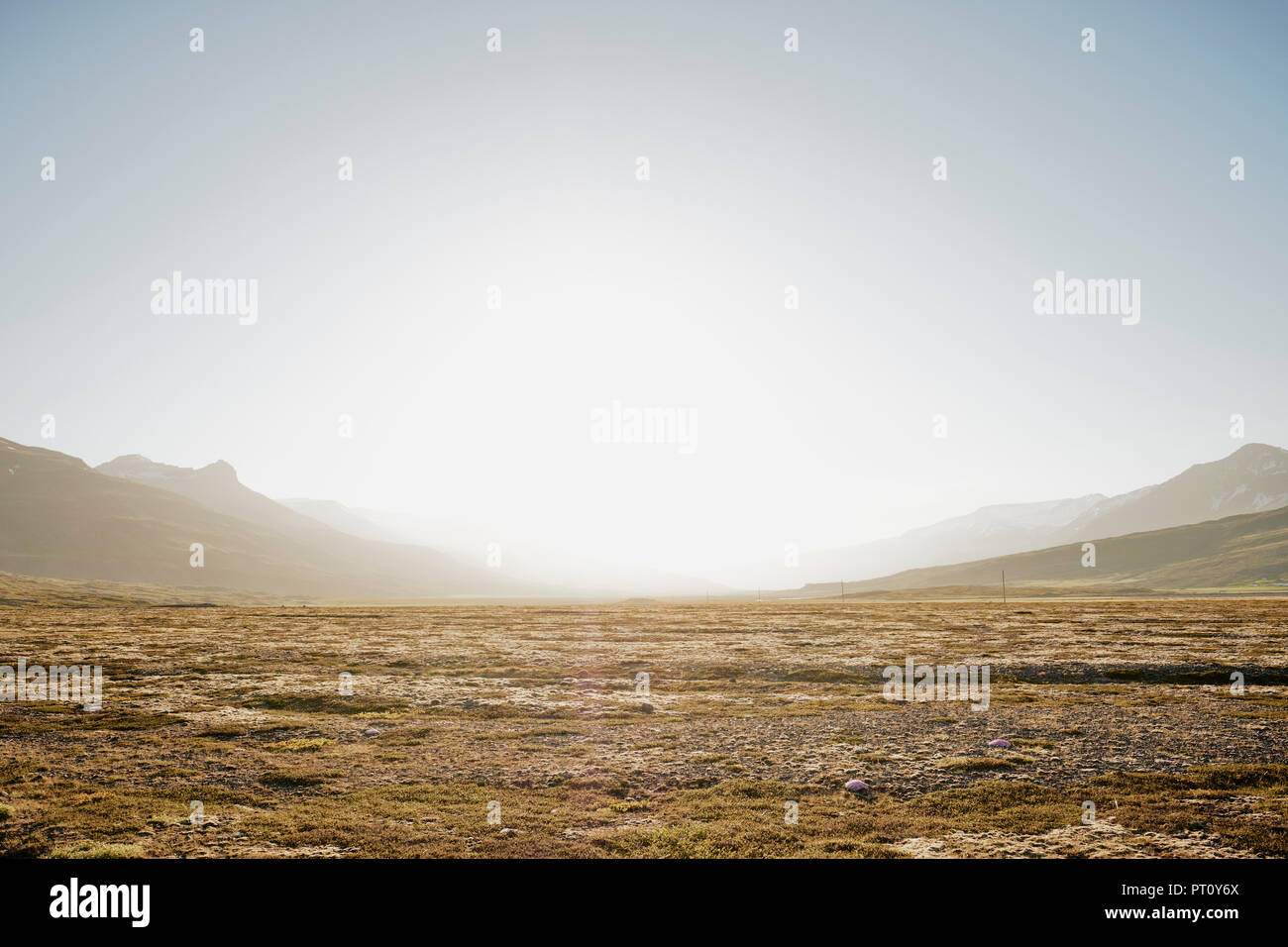 An empty Iceland landscape with mountains and moorland back lit by bright sunlight in a clear sky with copyspace - Iceland minimalism Stock Photo