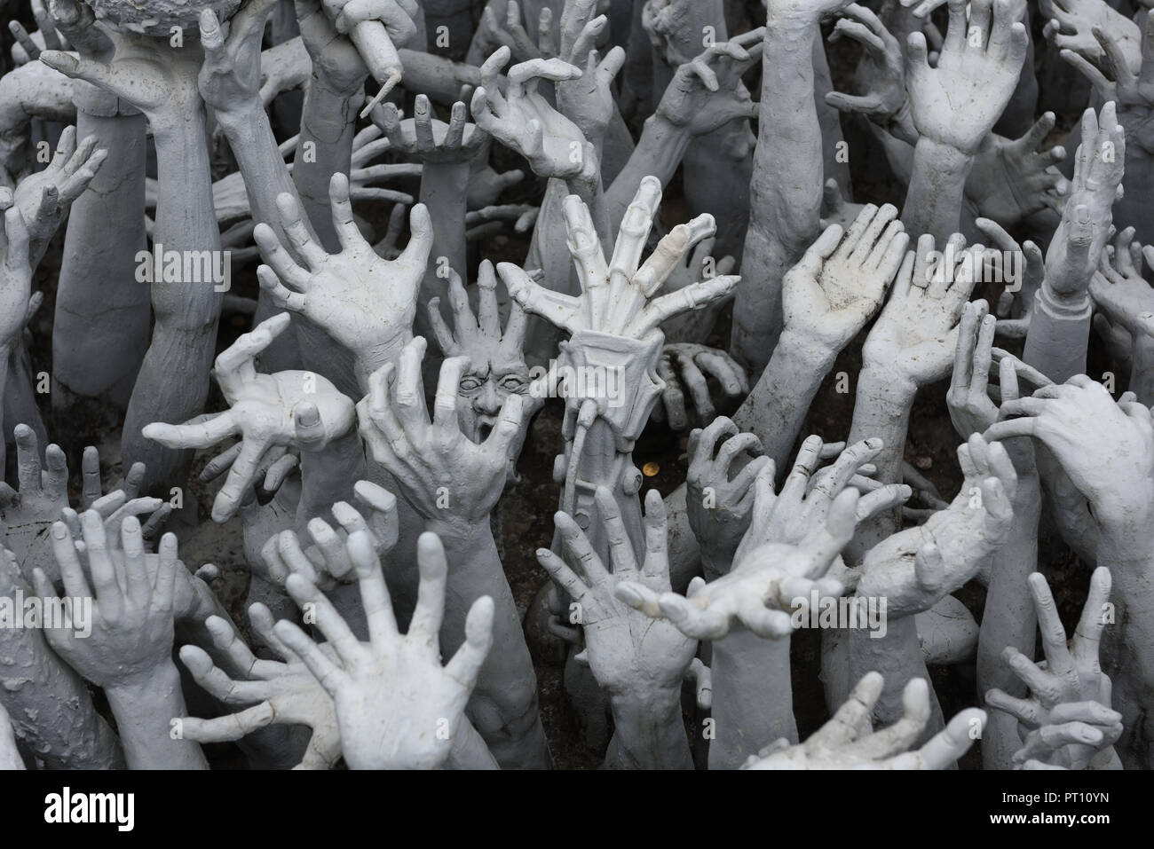 Carved hands reaching out by the artist Chalermchai Kositpipat in the grounds of Wat Rong Khun, Chiang Rai Province, Thailand Stock Photo