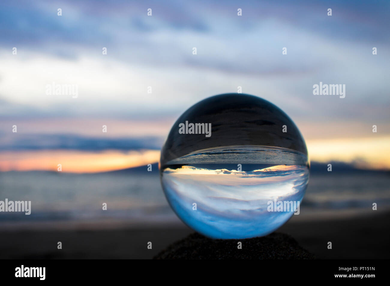 Seascape sunset with island on horizon captured in reflection in glass ...