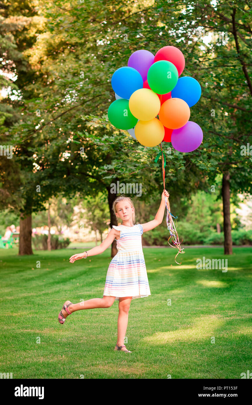 Girl flying balloons in sky hi-res stock photography and images - Alamy