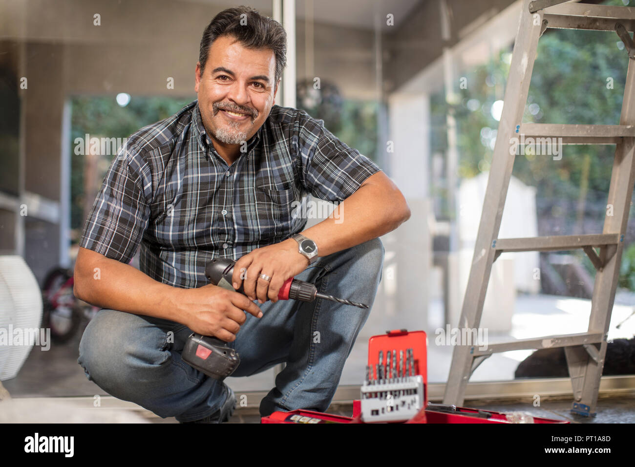 Portrait of smiling man with portable drill Stock Photo