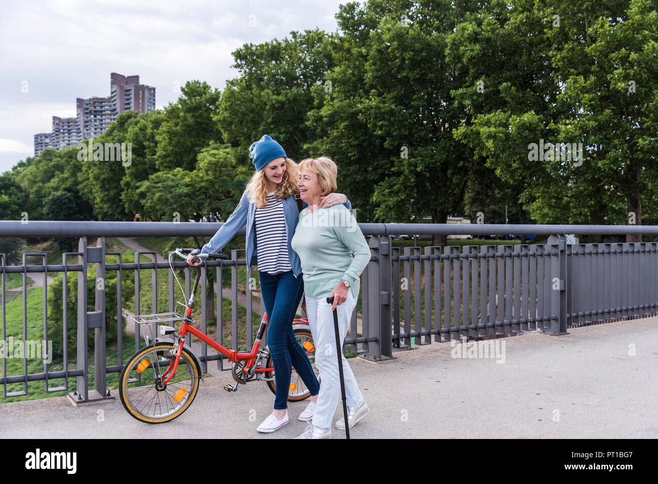 Grandmother and granddaughter strolling on a bridge Stock Photo