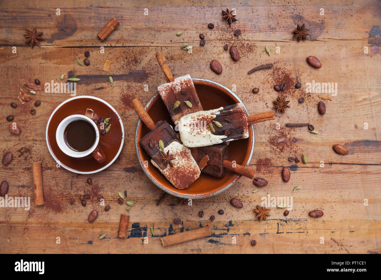 Homemade espresso and white chocolate ice lollies with winter spices and cup of espresso on wooden background Stock Photo