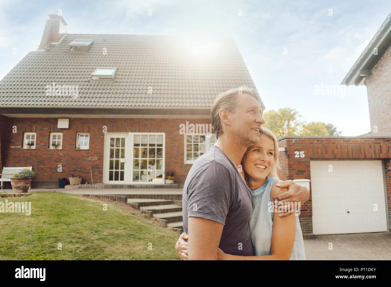 Smiling mature couple embracing in garden of their home Stock Photo - Alamy