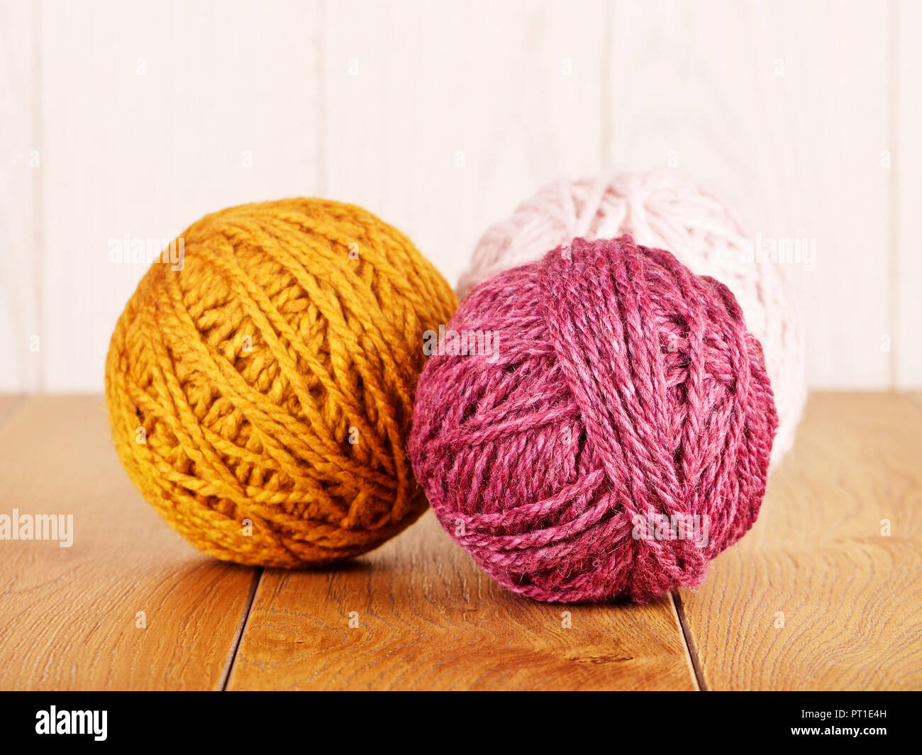 colorful yarn balls lying on wooden background Stock Photo