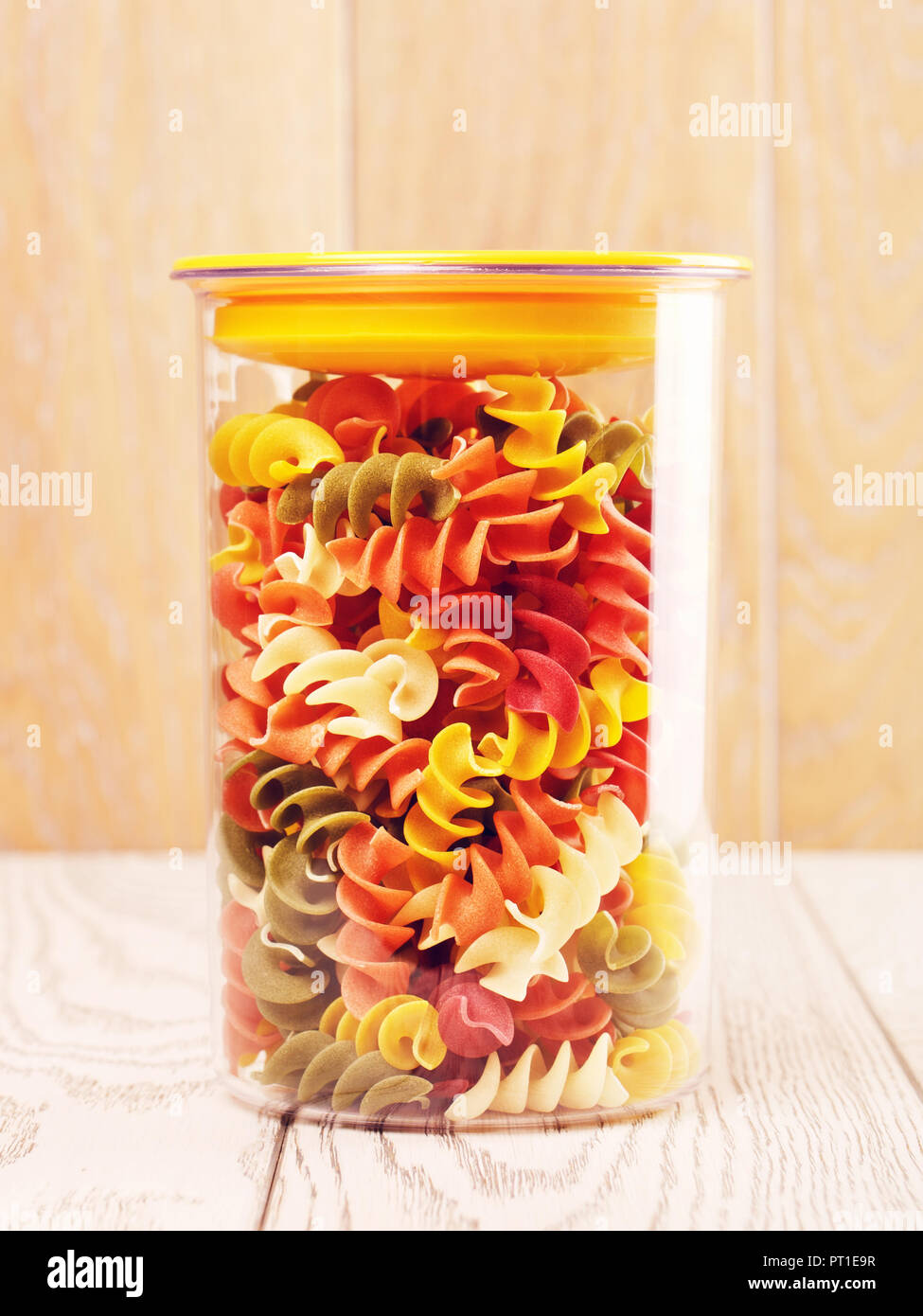 raw spiral pasta of different color in plastic container Stock Photo