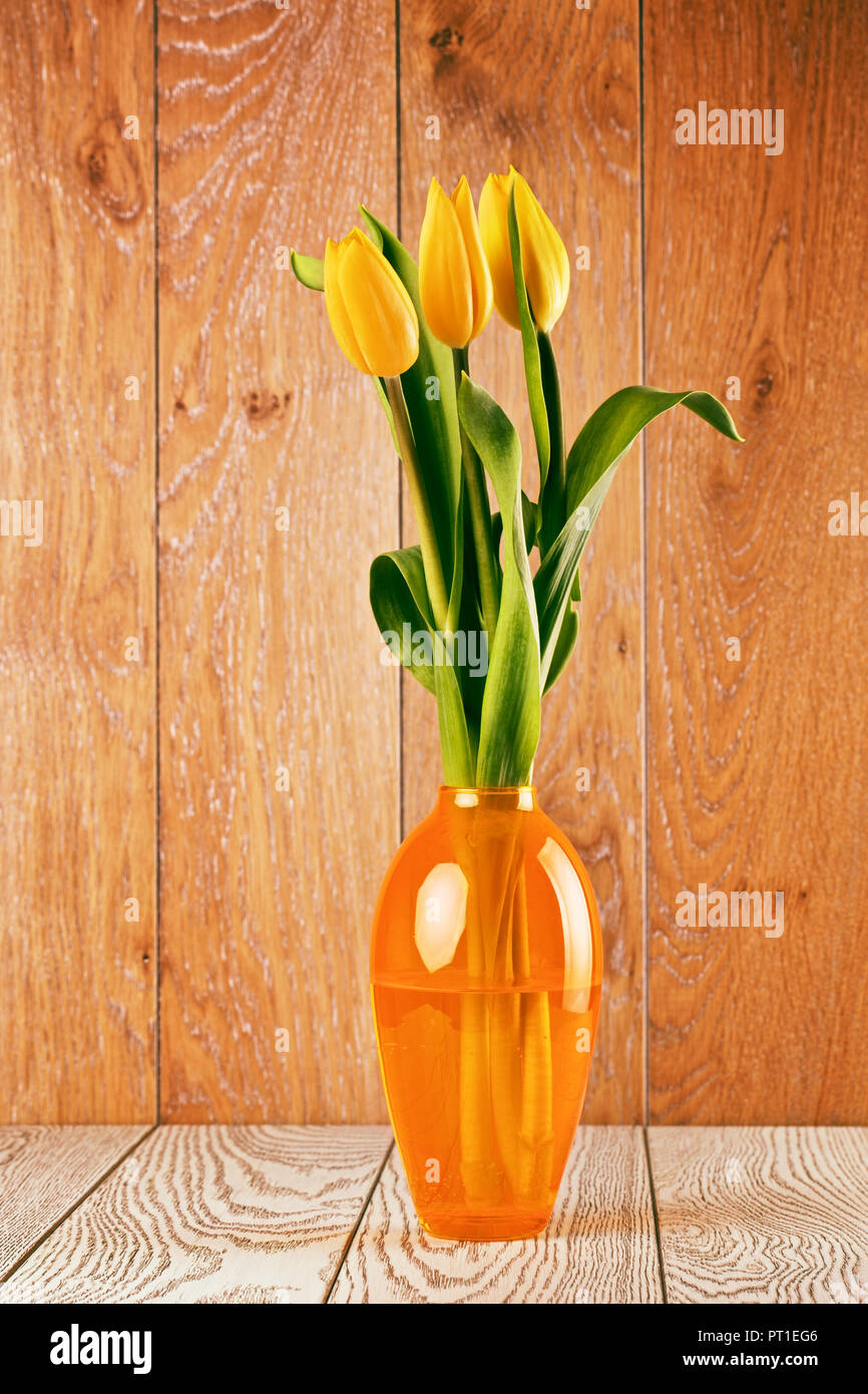 tulip flowers bouquet in vase on wooden background Stock Photo