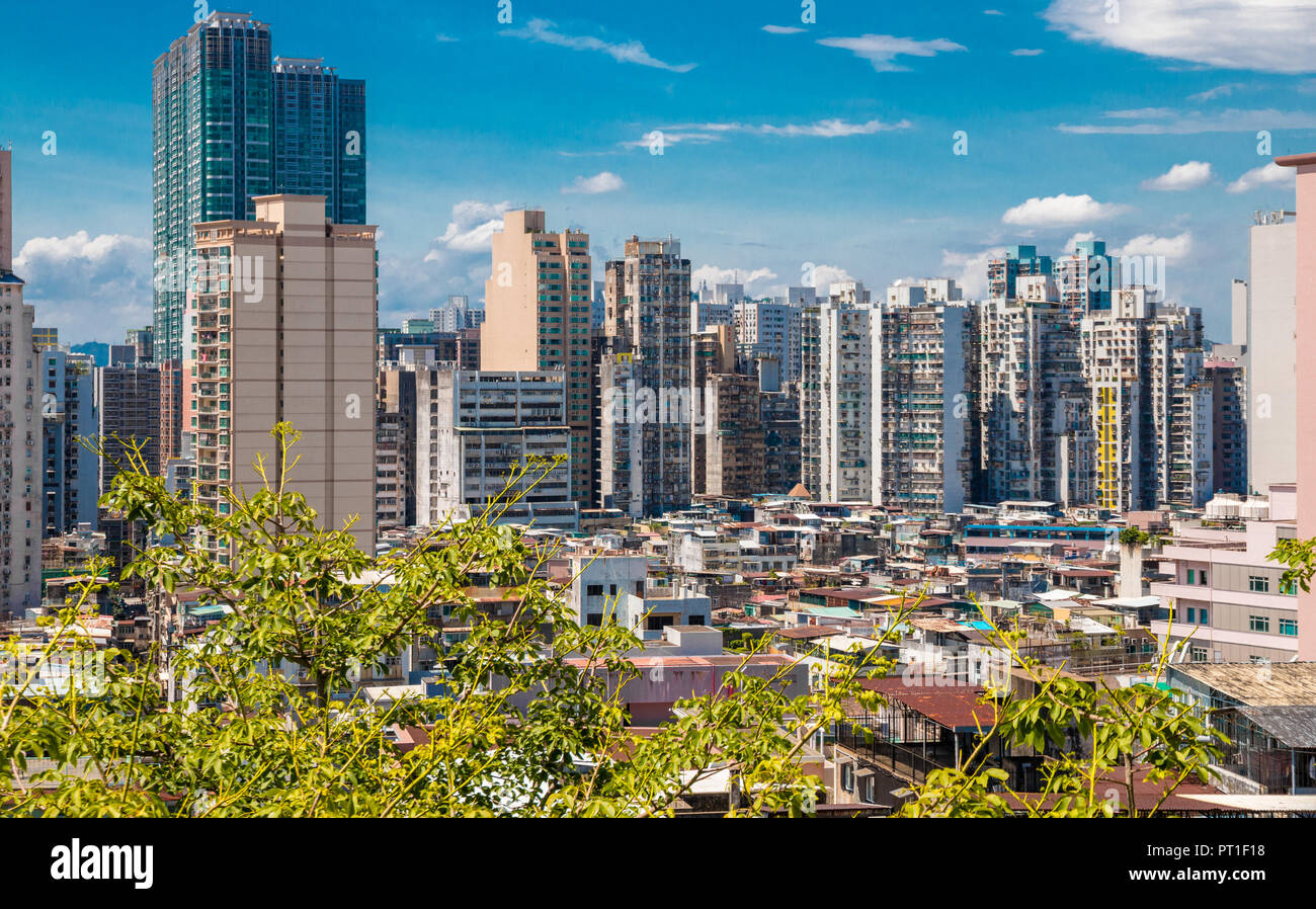 View of the housing area in Macau's historic city centre on a beautiful sunny day with a blue sky. The high-rise buildings are surrounding the older... Stock Photo