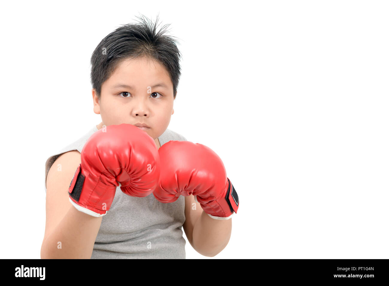 Handsome boy fighting with red boxing gloves isolated on white