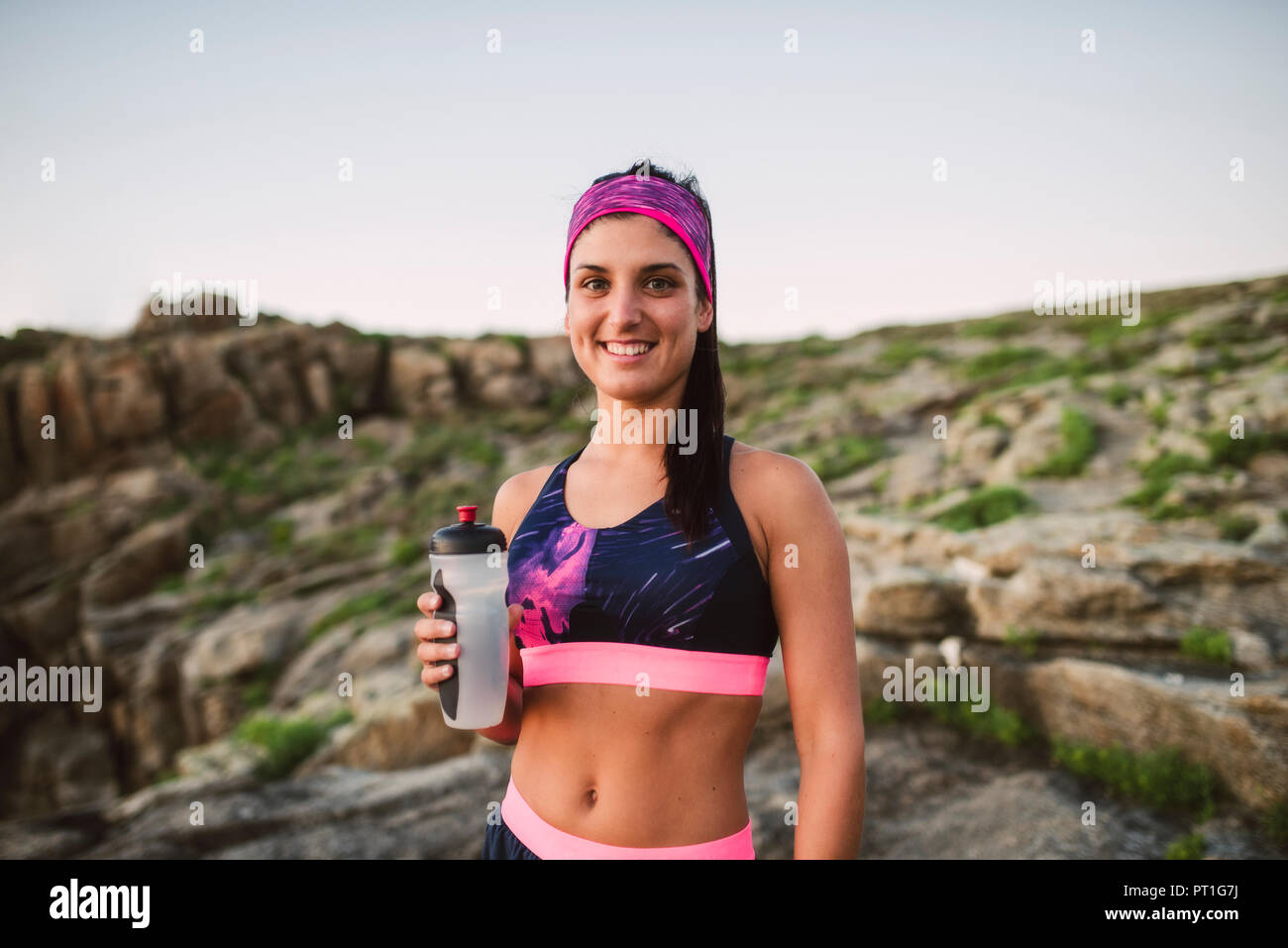 Portrait of an athlete woman drinking water outdoors Stock Photo