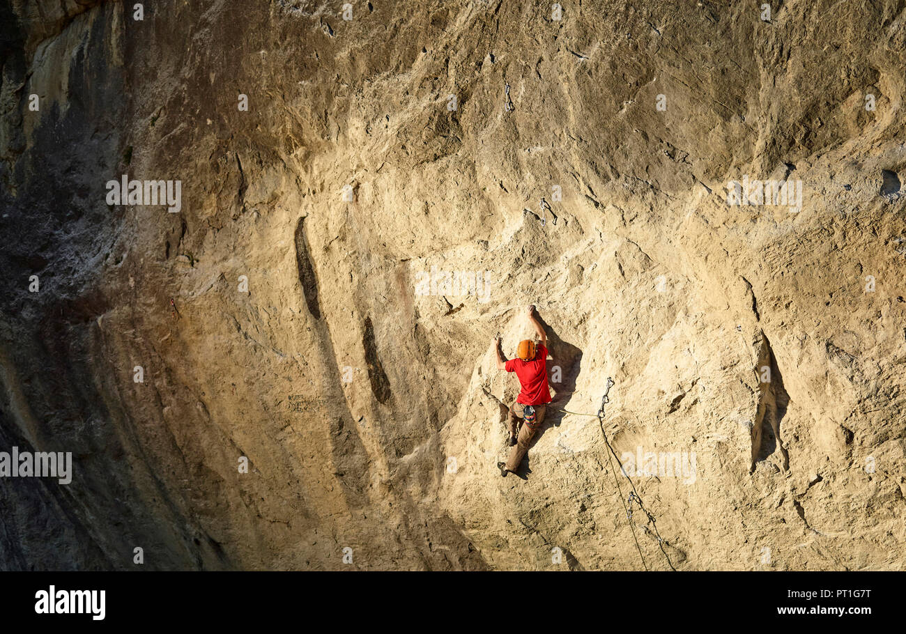 Austria, Innsbruck, Martinswand, man climbing in rock wall Stock Photo
