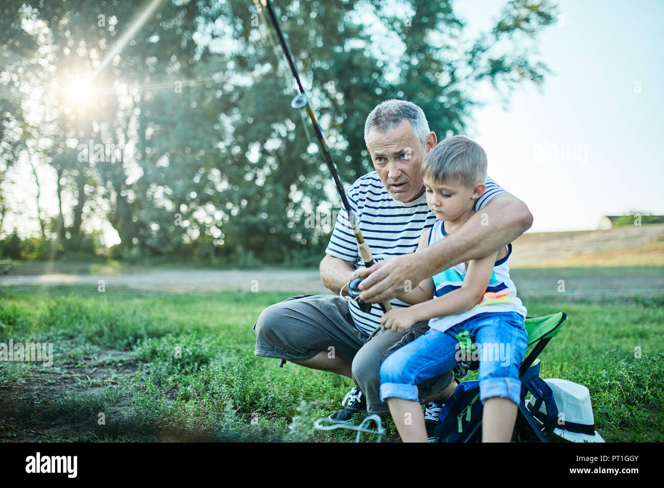 Grandfather and grandson fishing together at lakeshore Stock Photo - Alamy
