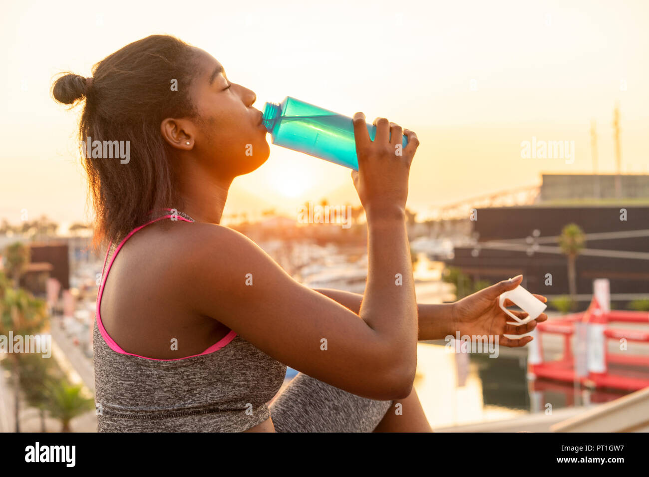 Young woman drinking water during work out Stock Photo