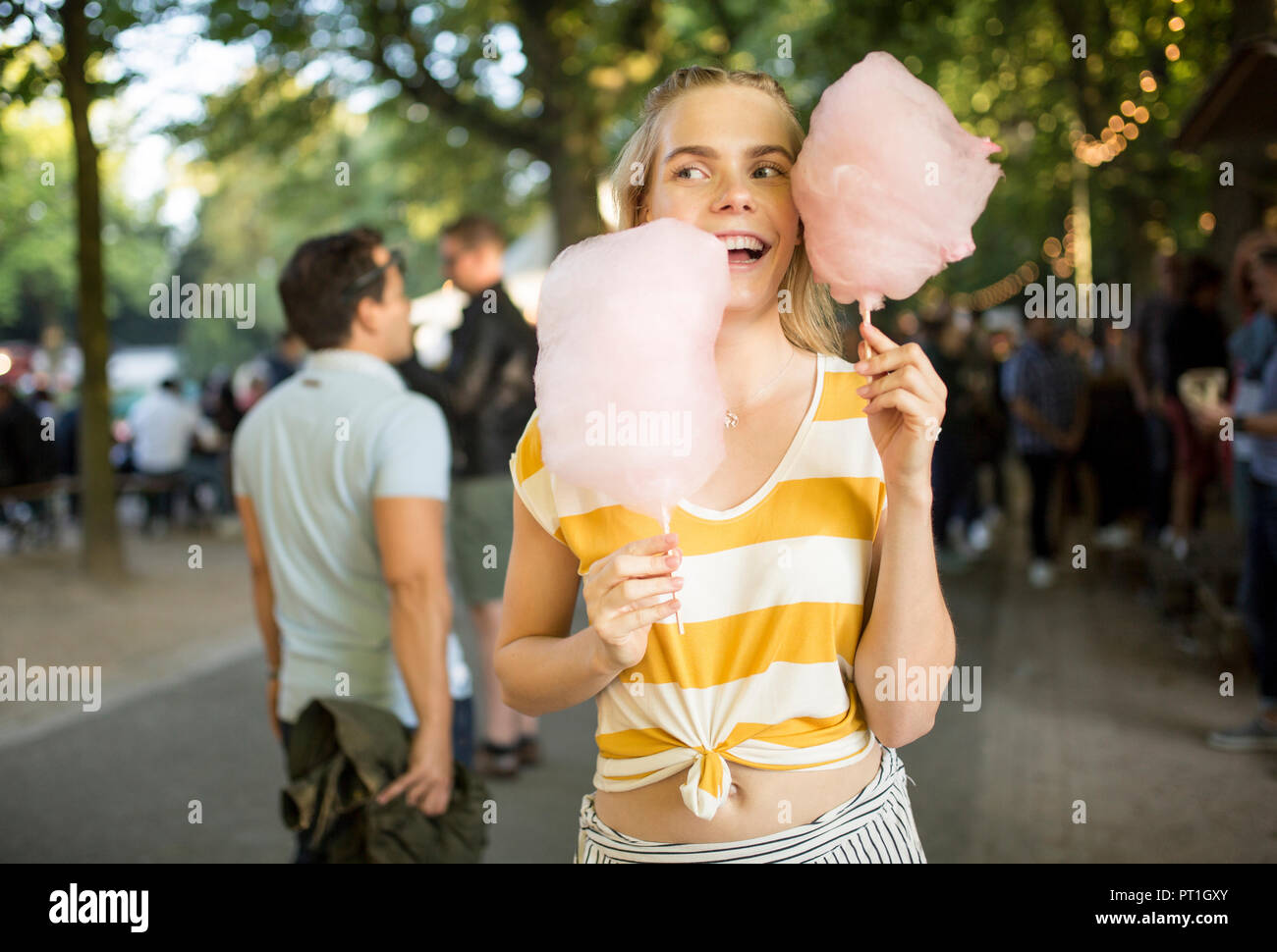 Portrait of young woman with pink candy floss on streetfood festival Stock Photo