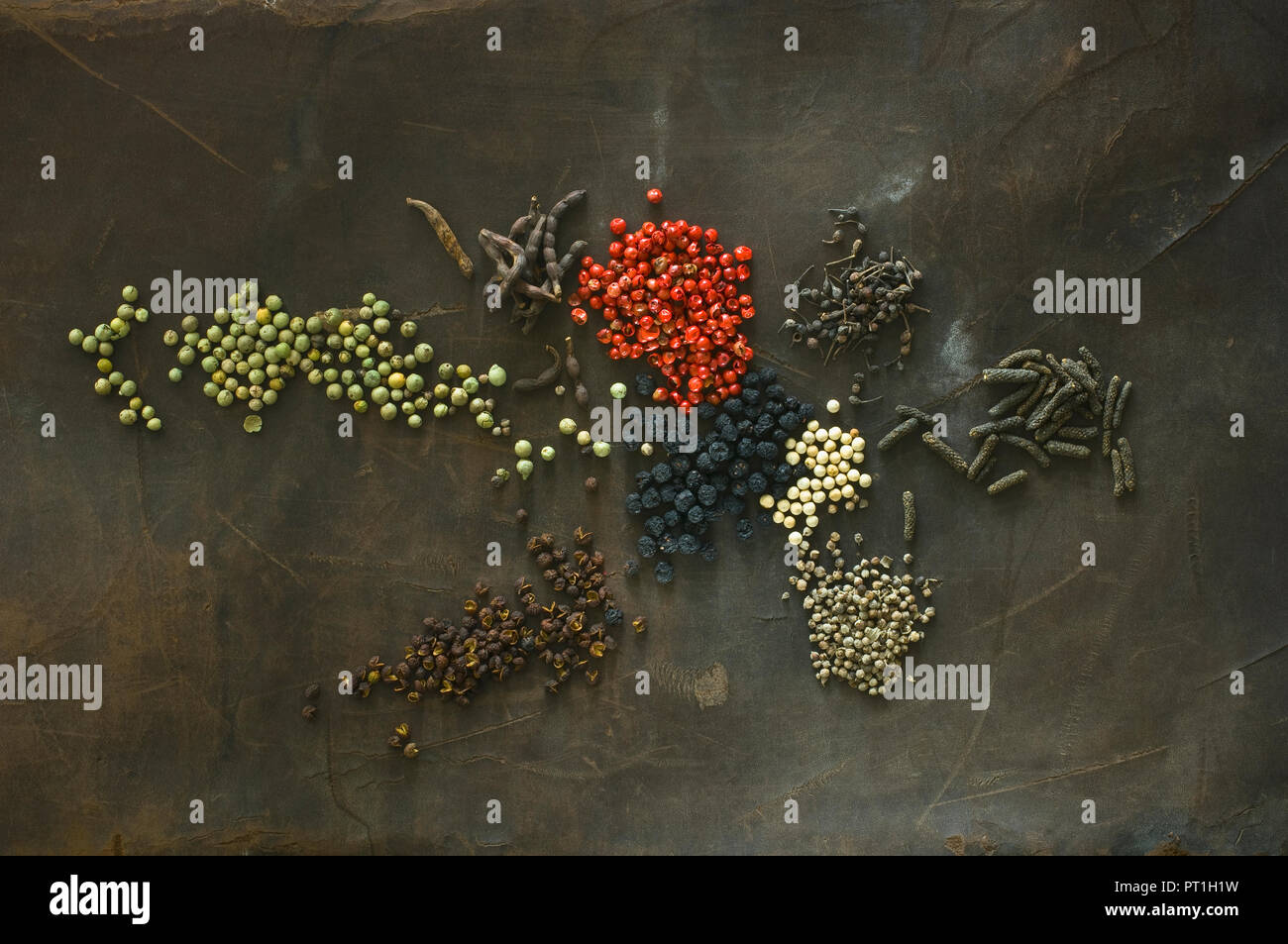 Various sorts of pepper on brown background Stock Photo