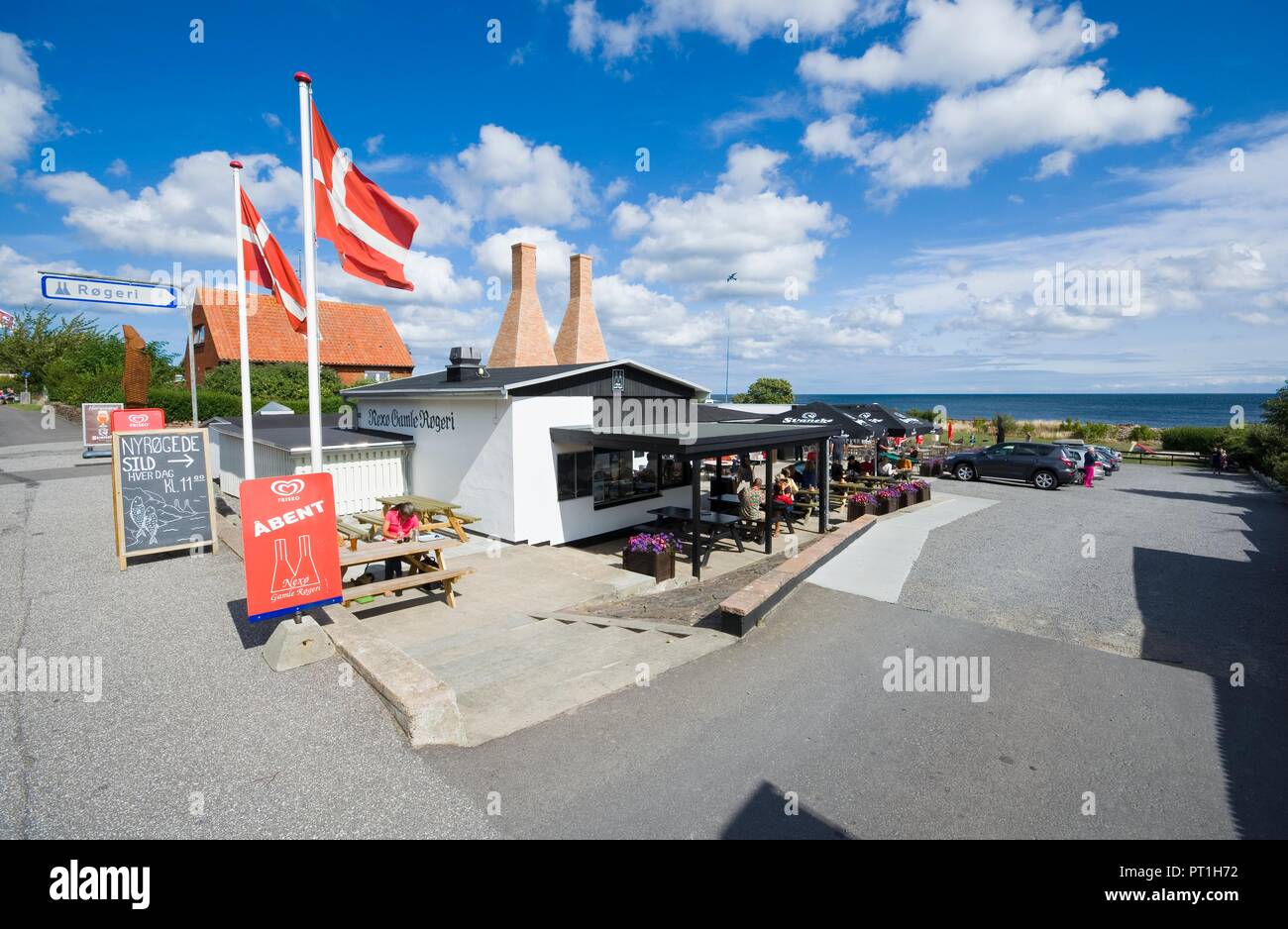 NEXO, DENMARK - AUGUST 20, 2018: Nexo Gamle Rogeri - traditional smokehouse with characteristic chimneys, where you can taste the most popular dish on Stock Photo