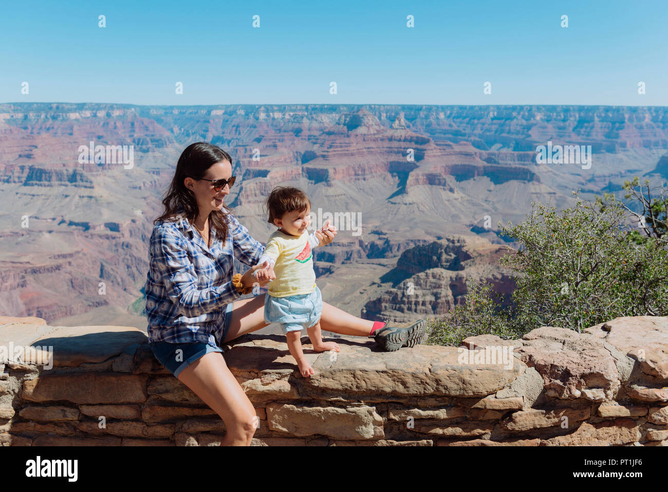 USA, Arizona, Grand Canyon National Park, Grand Canyon Village, mother and little daughter on a wall Stock Photo