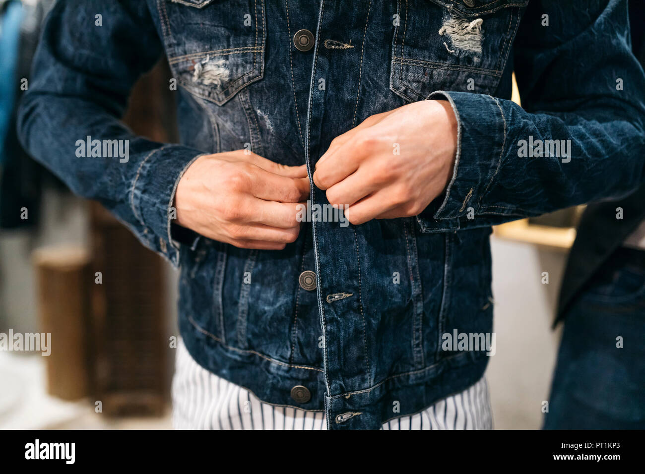 Man trying on new denim jacket Stock Photo