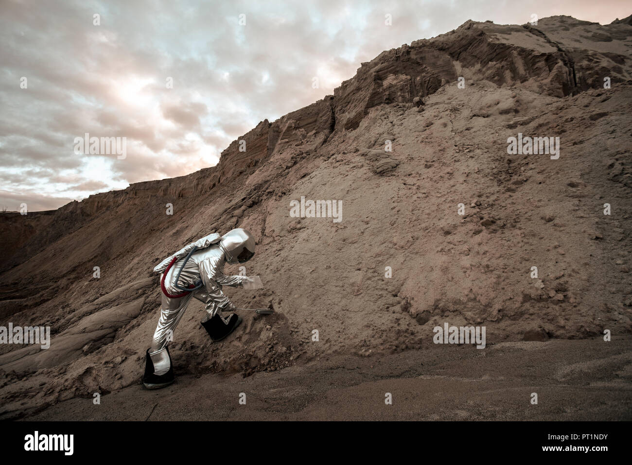 Spaceman on nameless planet taking samples of sand Stock Photo